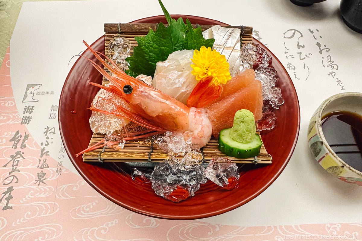 assorted sashimi served on a red lacquer bowl