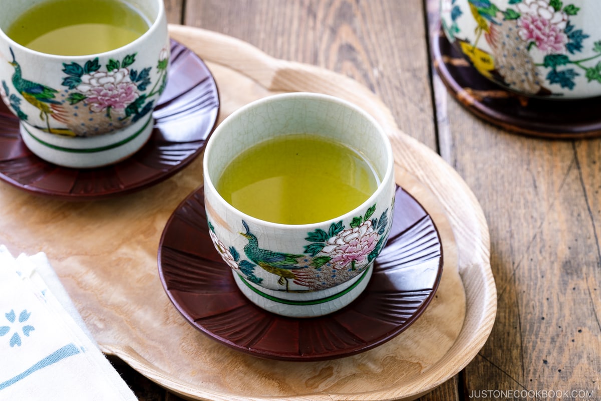 green tea in 2 ceramic teacups on a wooden table