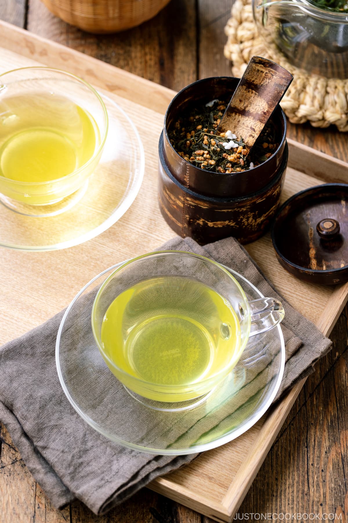 green tea in 2 glass teacups on a wooden tray