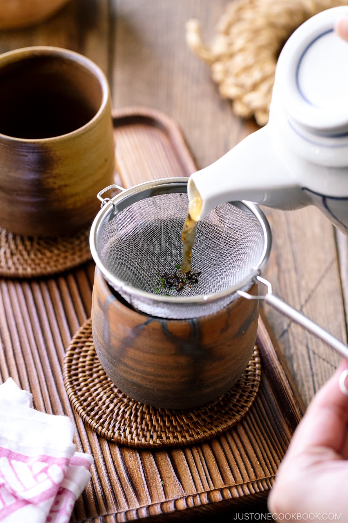 hojicha being poured into a ceramic teacup