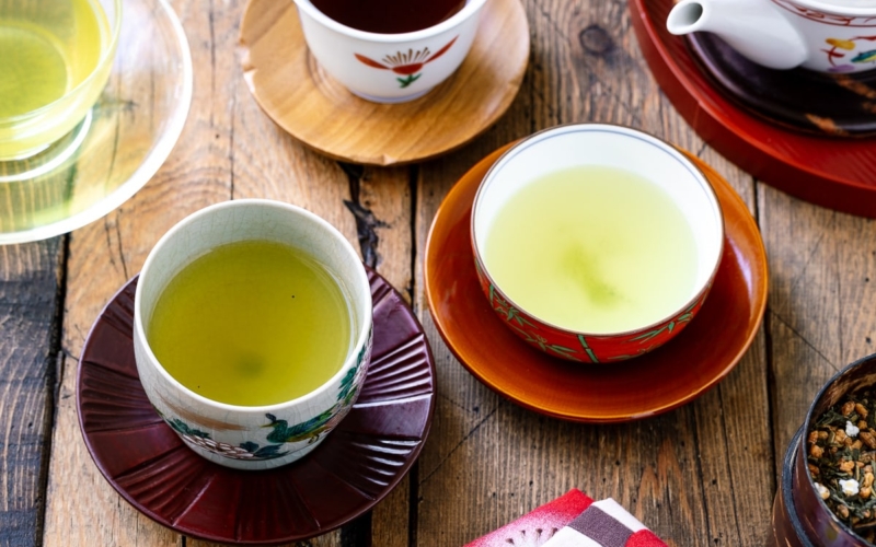 an assortment of green tea in teacups on a wooden table