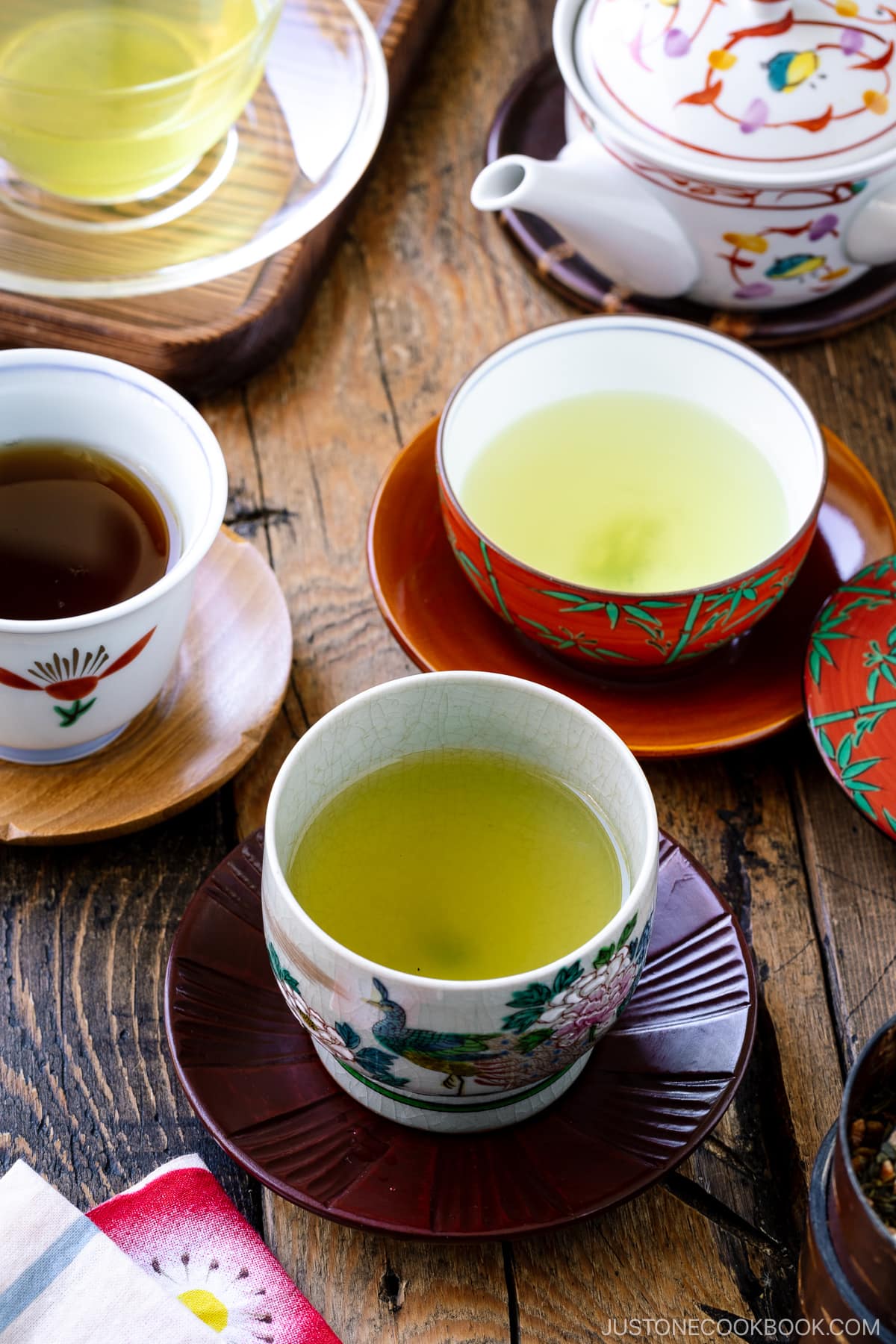 an assortment of green tea in teacups on a wooden table