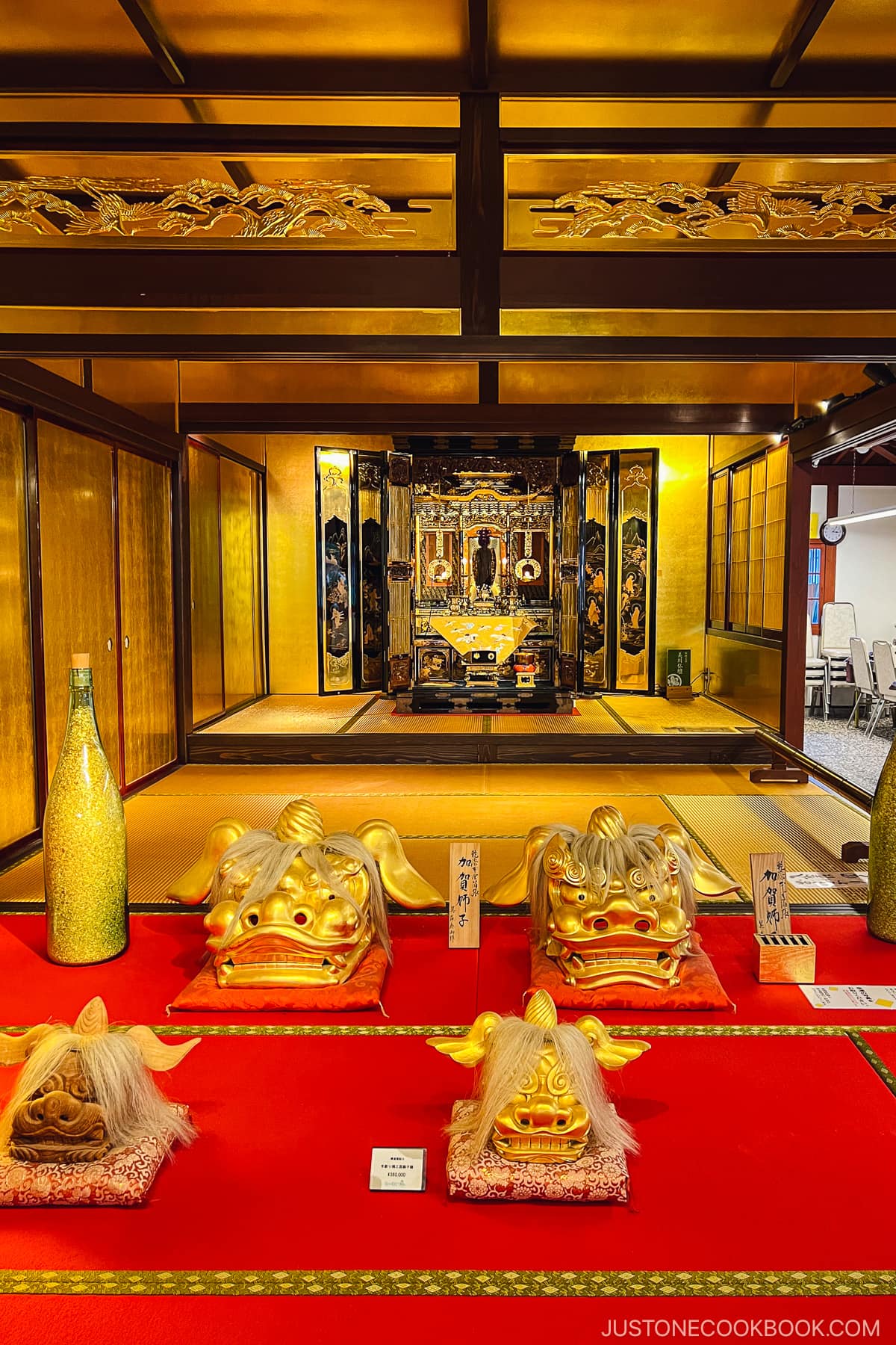 a room decorated in gold with an altar in the back