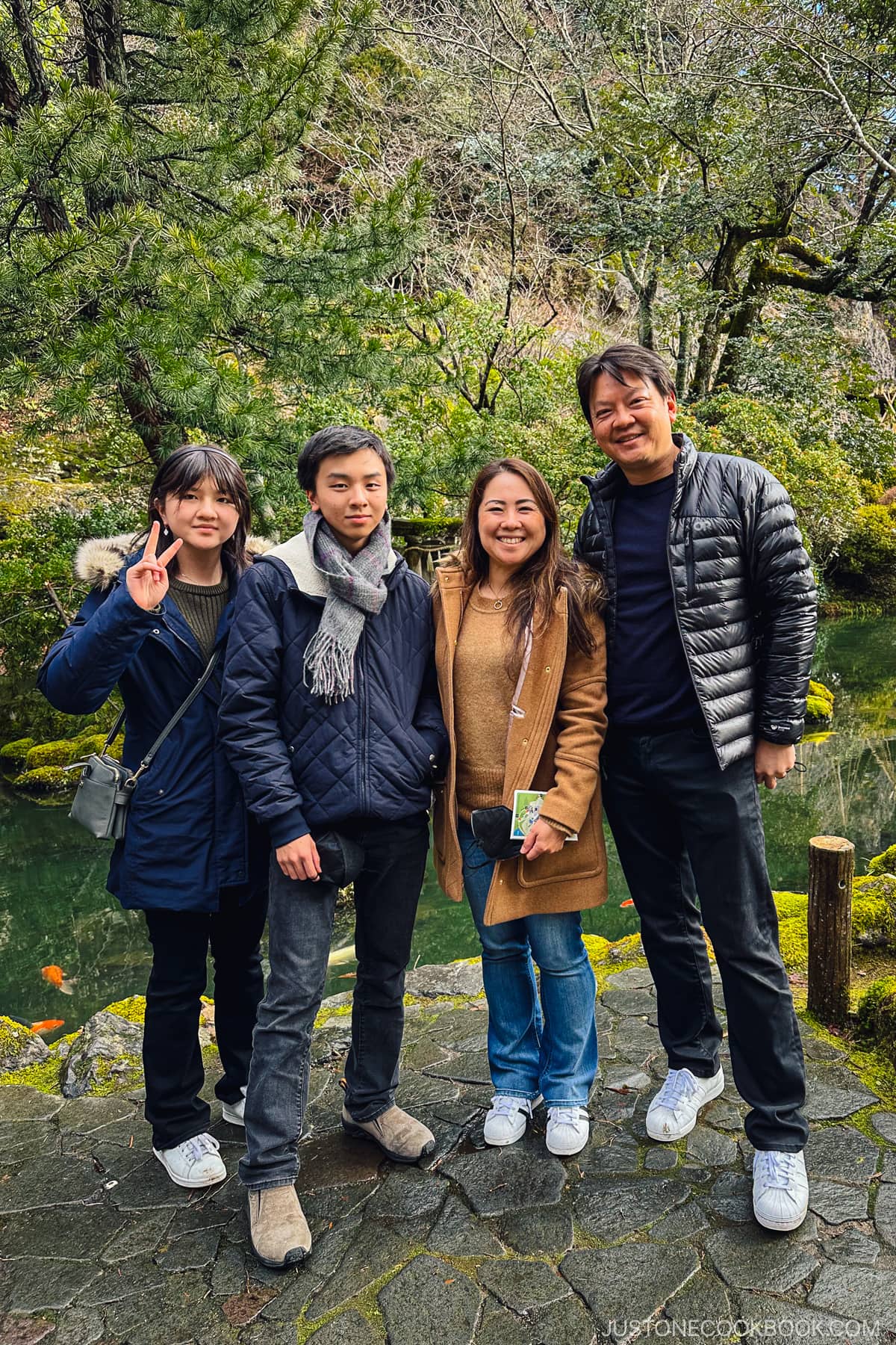 4 people in front of a pond