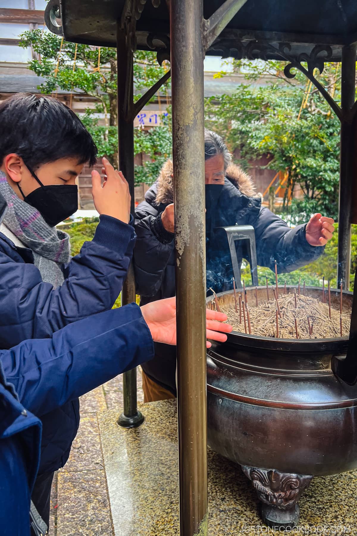 people surrounding burning incense