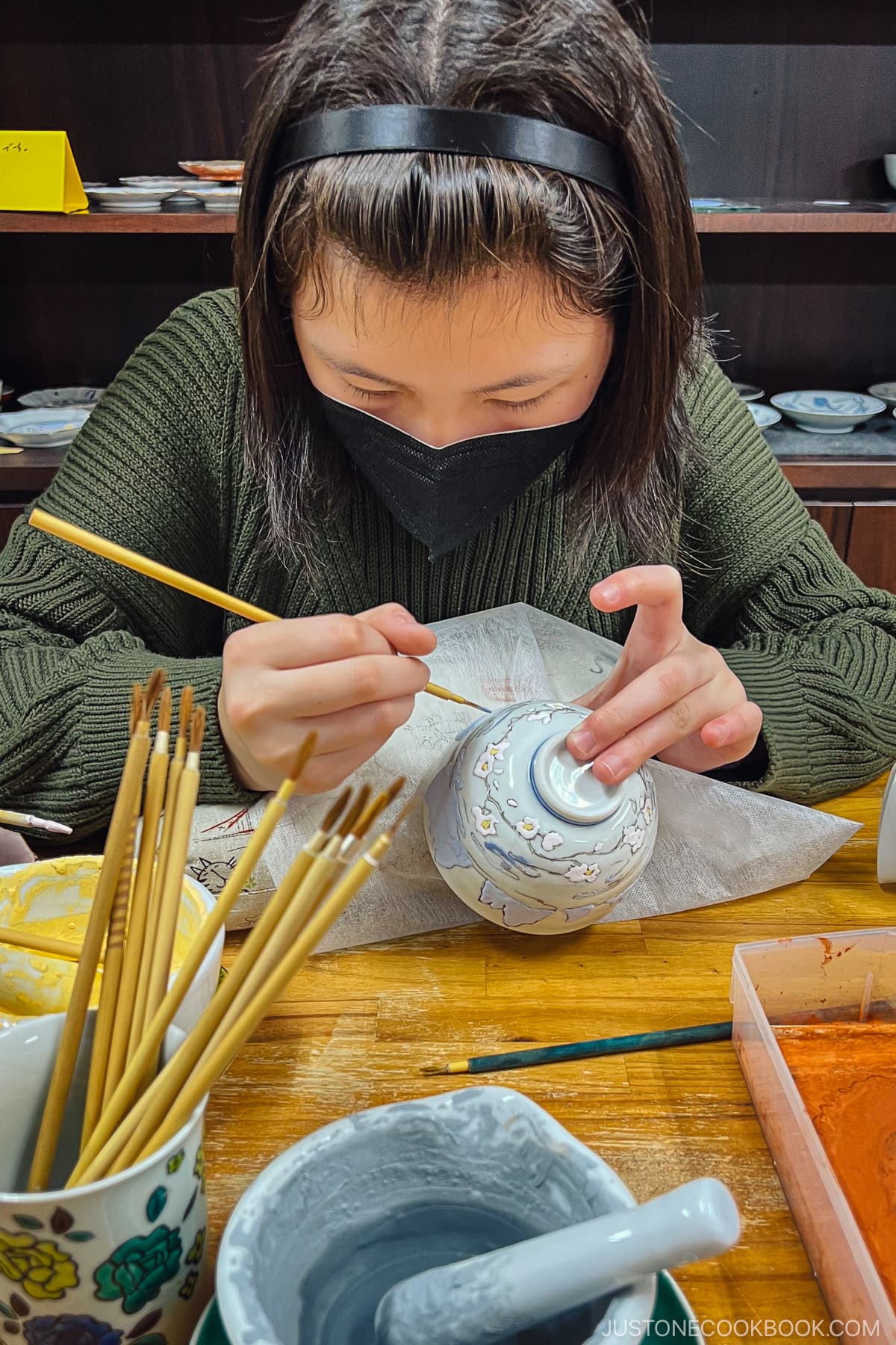 a person painting a porcelain bowl