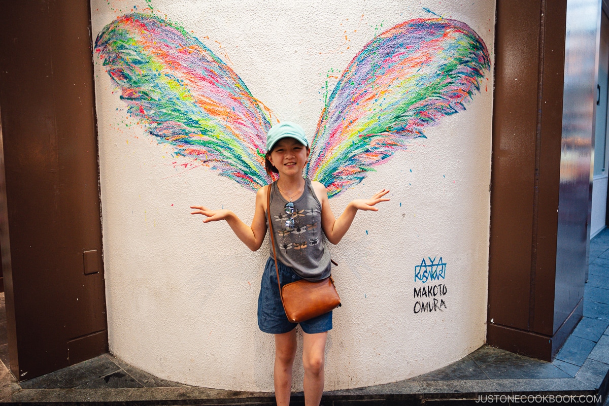 a girl standing in front of street art