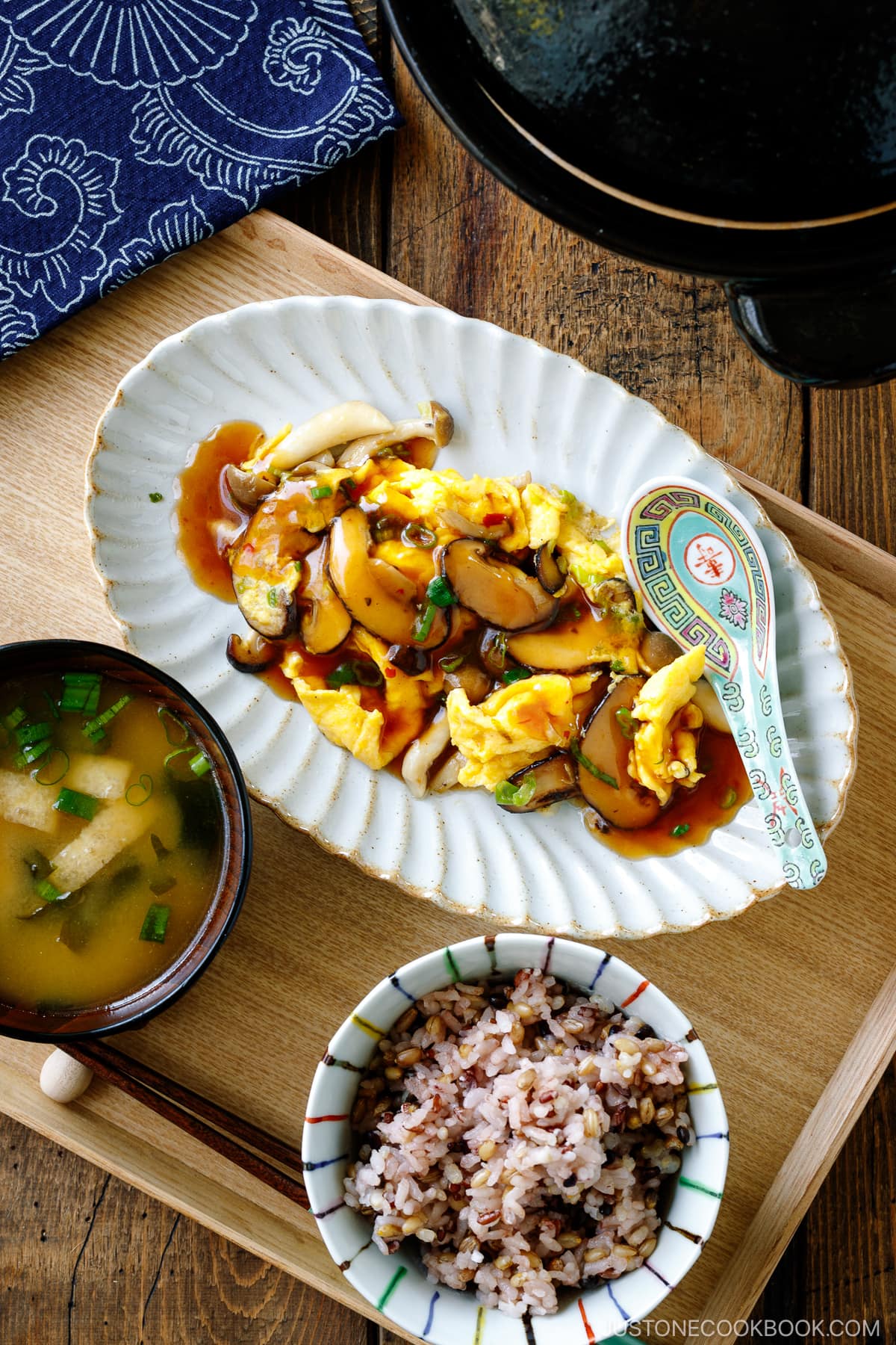 A fluted oval shape containing stir-fried mushrooms and eggs drizzled with ankake sauce.