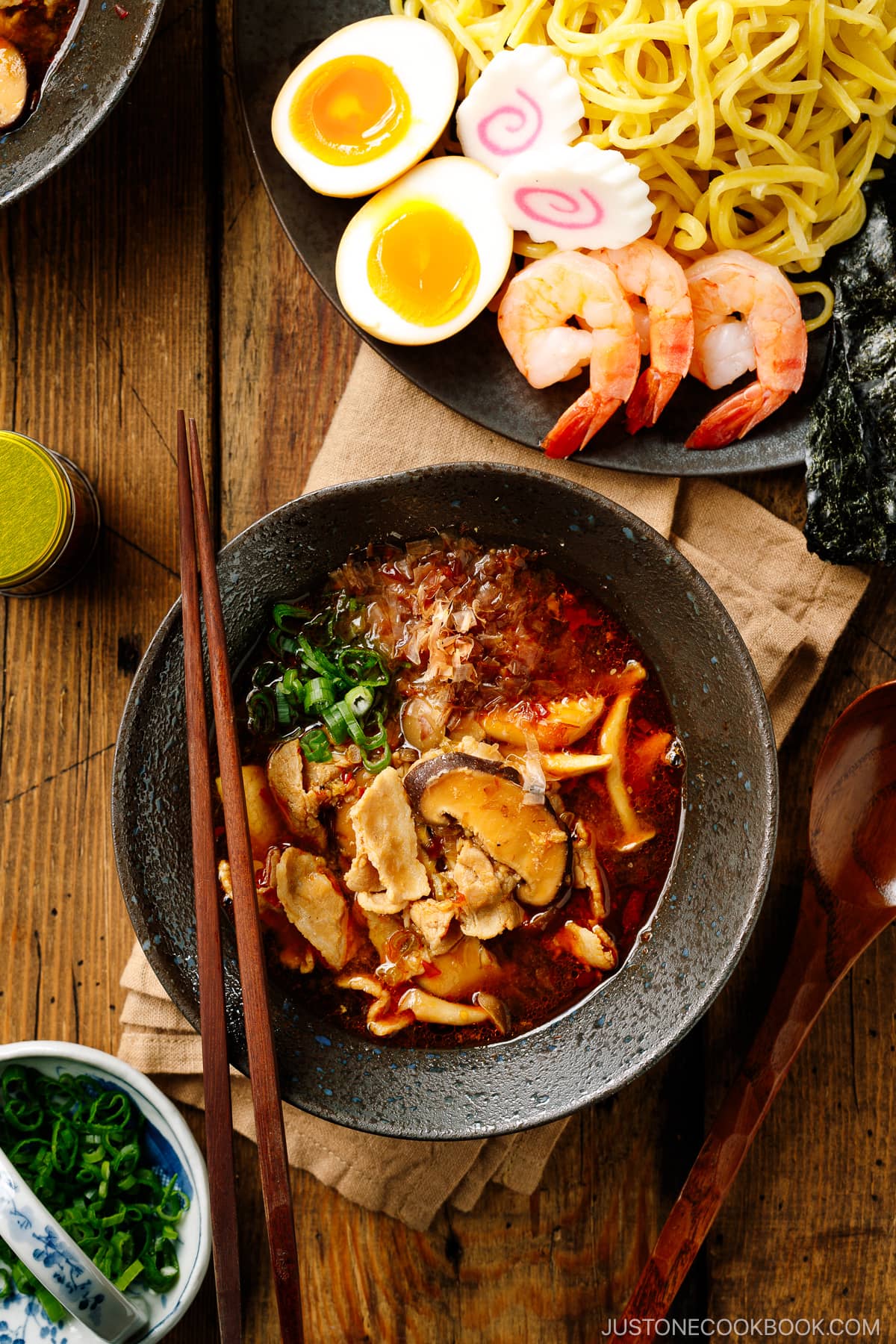 Bowls of Tsukemen dipping soup broth and a plate of ramen noodles and toppings.