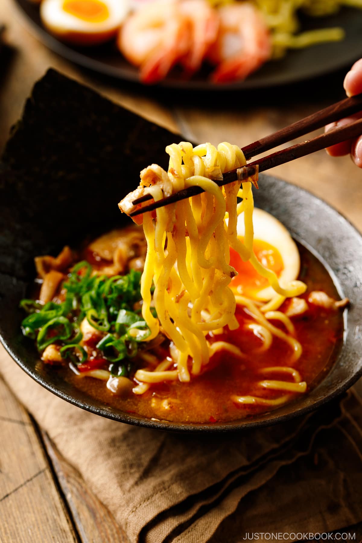 Bowls of Tsukemen dipping soup broth and a plate of ramen noodles and toppings.