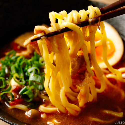 Bowls of Tsukemen dipping soup broth and a plate of ramen noodles and toppings.