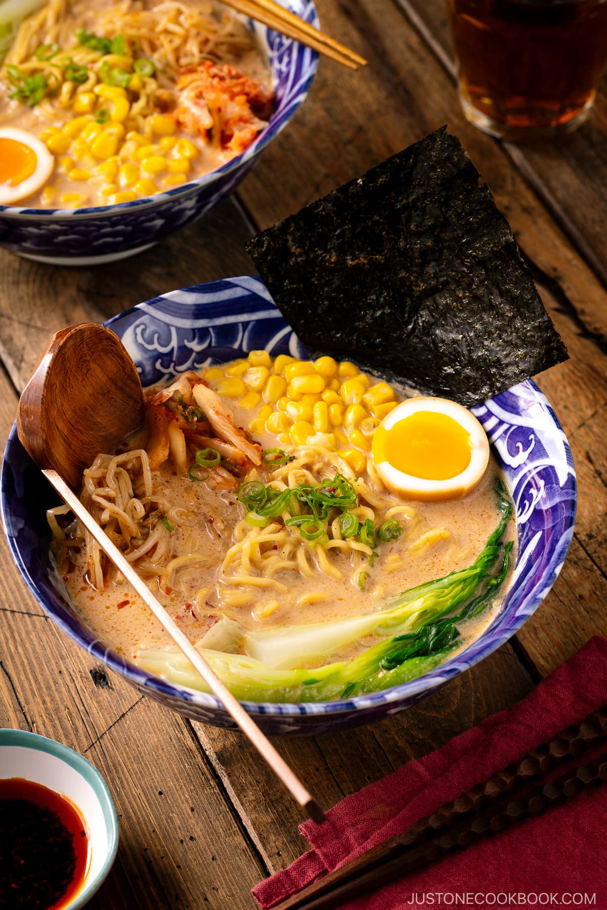 A bowl of Vegetarian Ramen topped with ajitama (soy marinated egg), spicy bean sprouts, corn, and a green veggie.