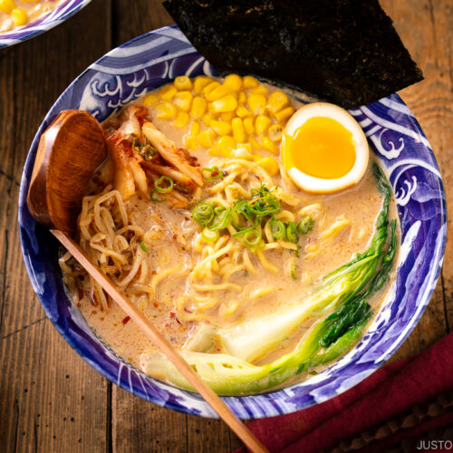 A bowl of Vegetarian Ramen topped with ajitama (soy marinated egg), spicy bean sprouts, corn, and a green veggie.