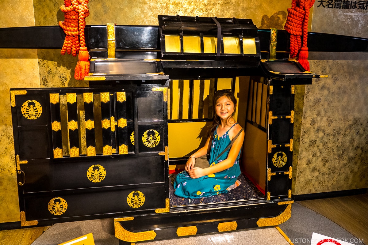 a girl sitting in a traditional coach
