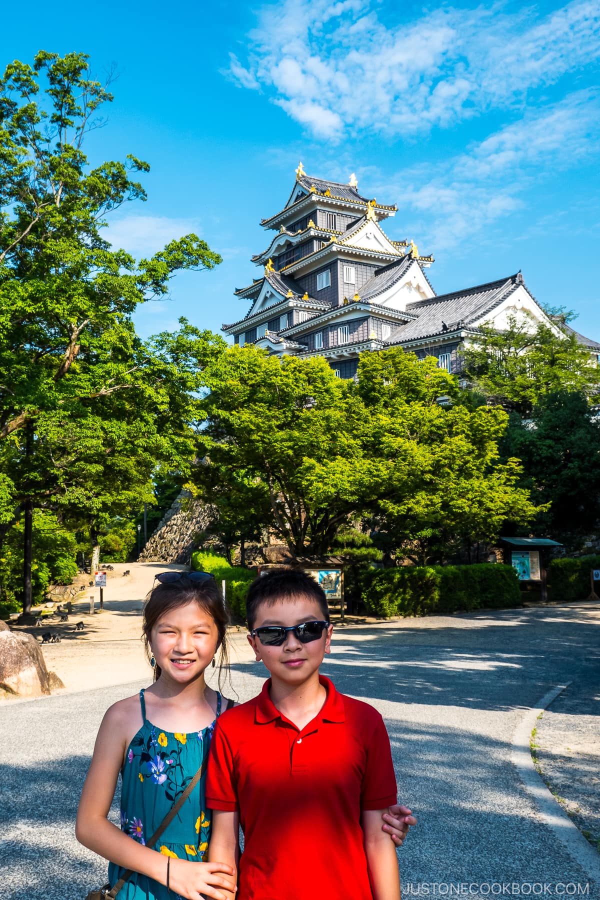 two children standing in front of Okayama Castle