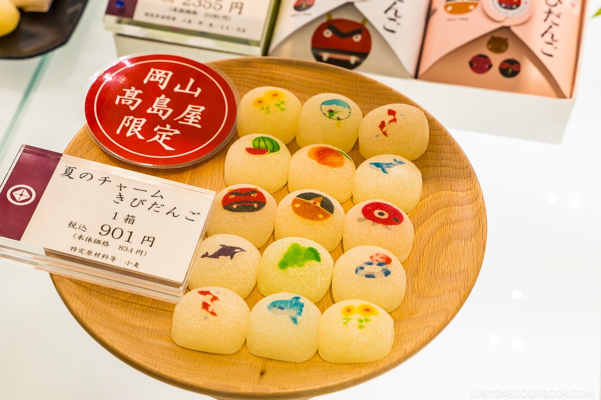 Kibi dango with colorful art on a wood plate