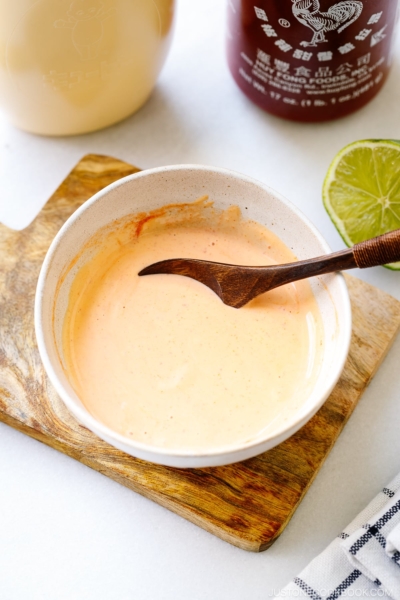 A white bowl containing spicy mayo.