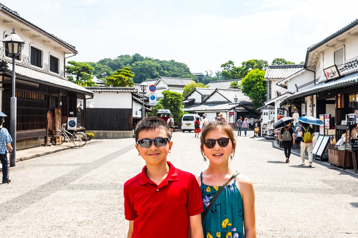 a boy and a girl standing on a road