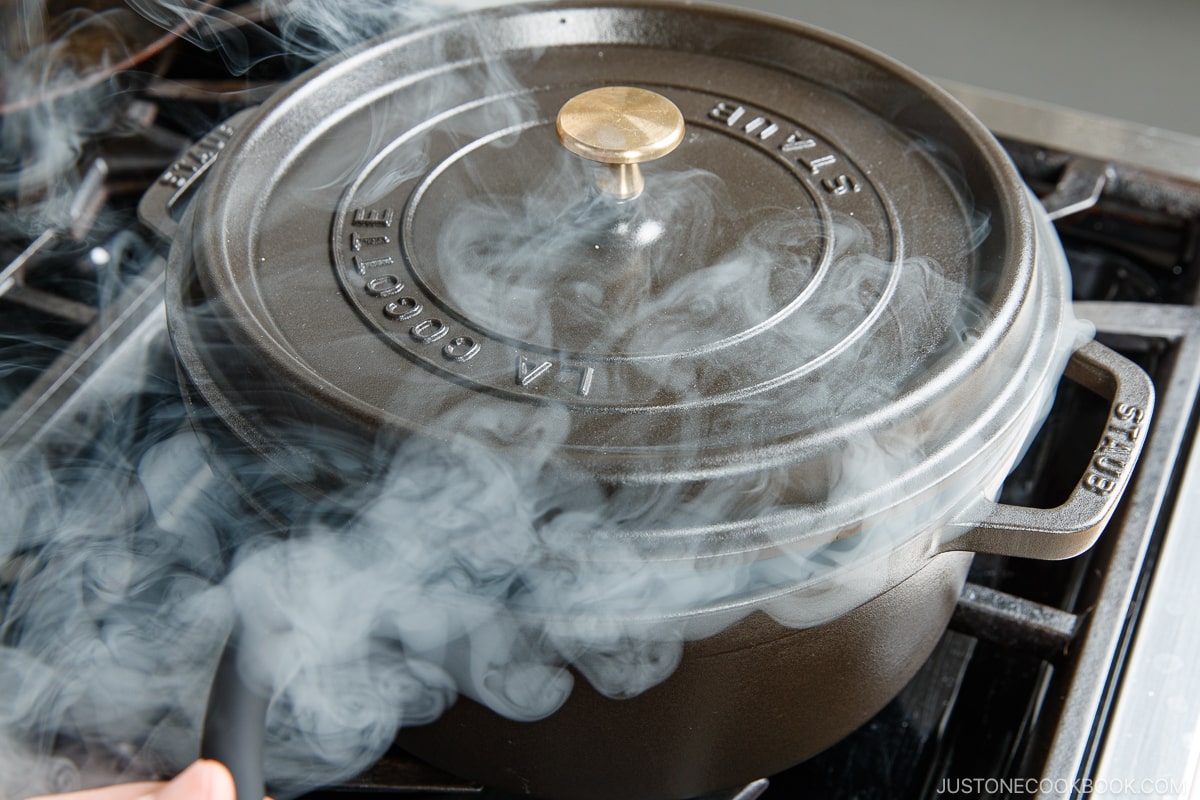 a pot on a stove with smoke coming out