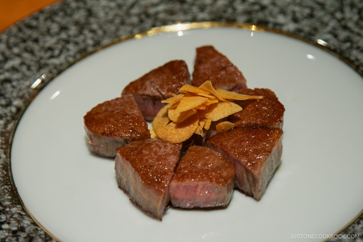 wagyu with fried garlic on a plate