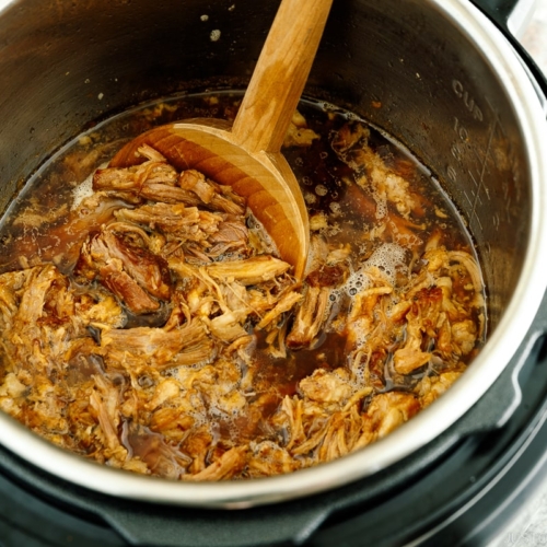 The Instant Pot containing juicy and fall-apart tender pulled pork.