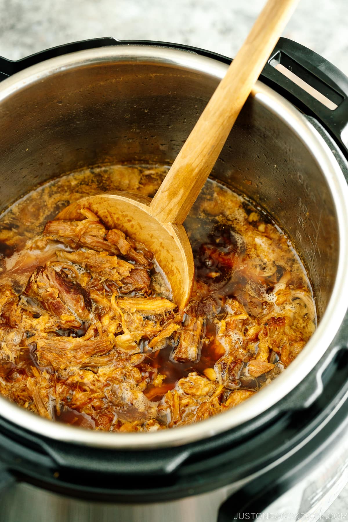 The Instant Pot containing juicy and fall-apart tender pulled pork.