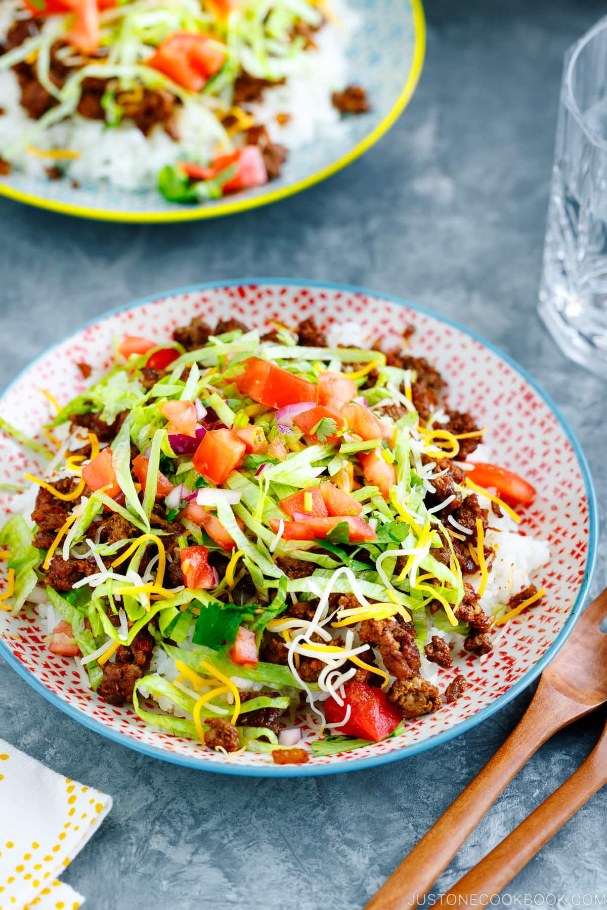 Colorful plates containing Okinawa Taco Rice with flavorful taco fixings served on a bed of hot Japanese white rice.