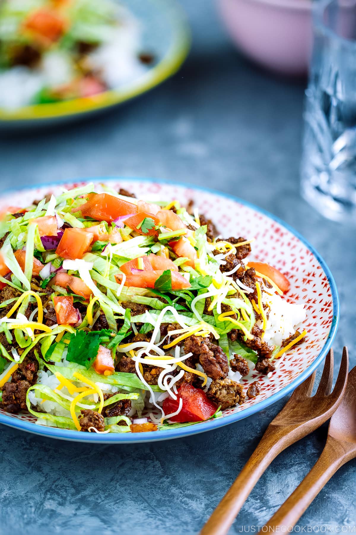 Colorful plates containing Okinawa Taco Rice with flavorful taco fixings served on a bed of hot Japanese white rice.