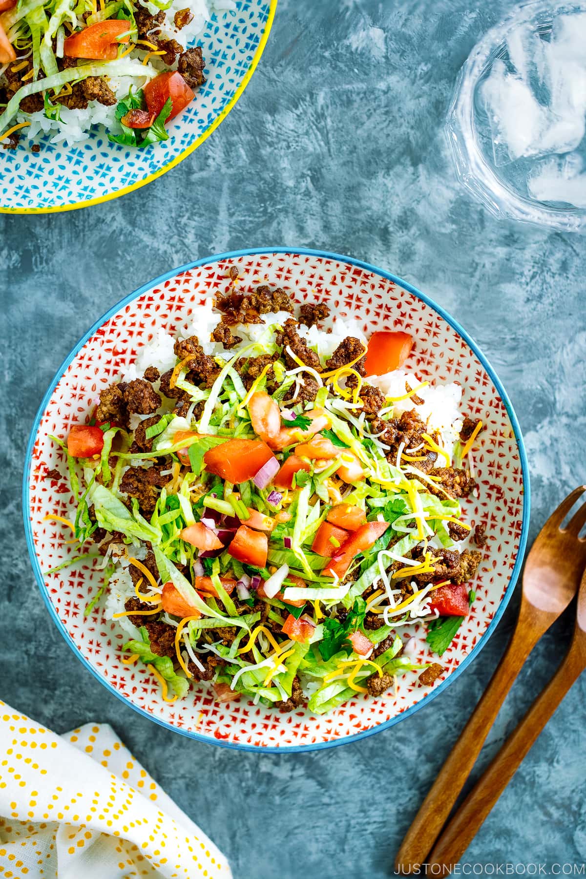 Colorful plates containing Okinawa Taco Rice with flavorful taco fixings served on a bed of hot Japanese white rice.