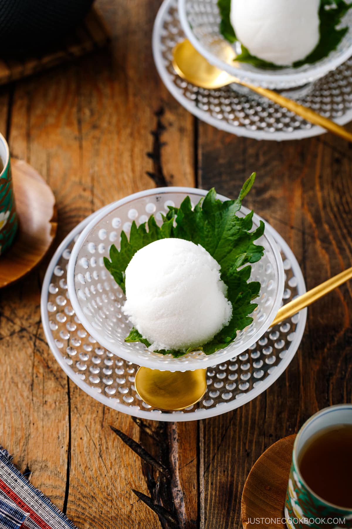 A white glass bowl containing Shiso Sorbet garnished with shiso leaf.