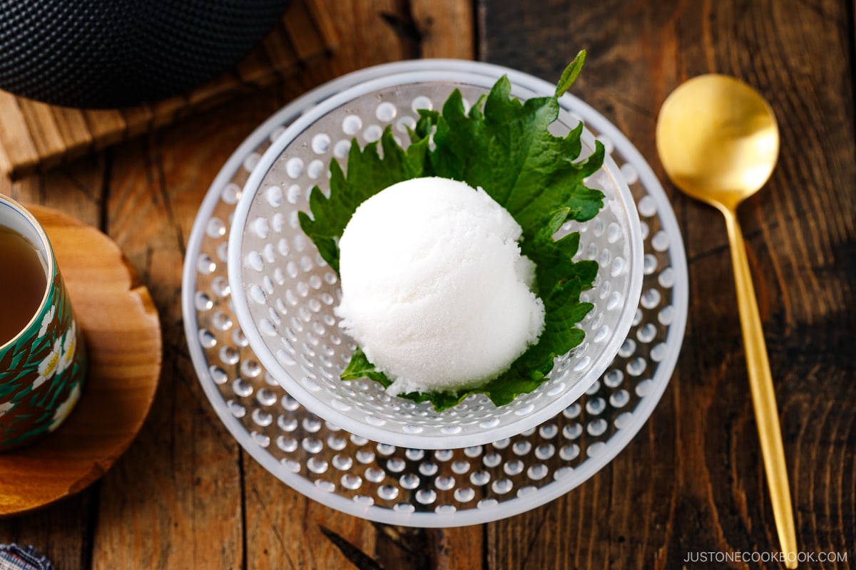 A white glass bowl containing Shiso Sorbet garnished with shiso leaf.