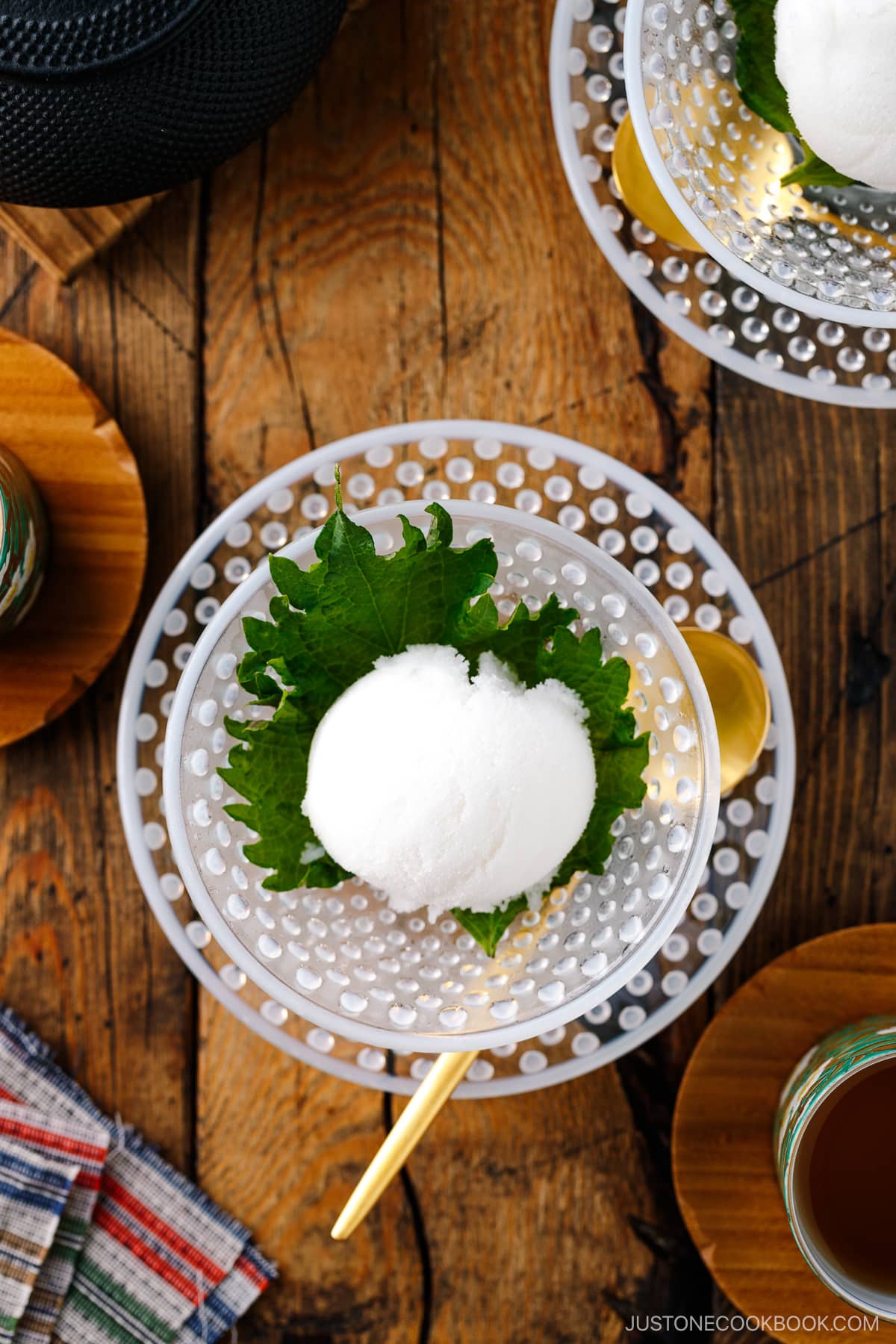 A white glass bowl containing Shiso Sorbet garnished with shiso leaf.