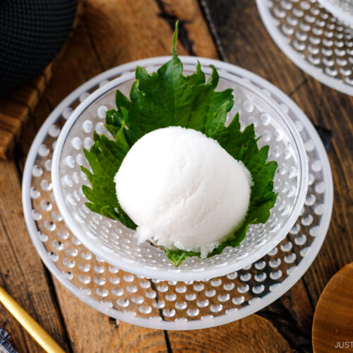 A white glass bowl containing Shiso Sorbet garnished with shiso leaf.