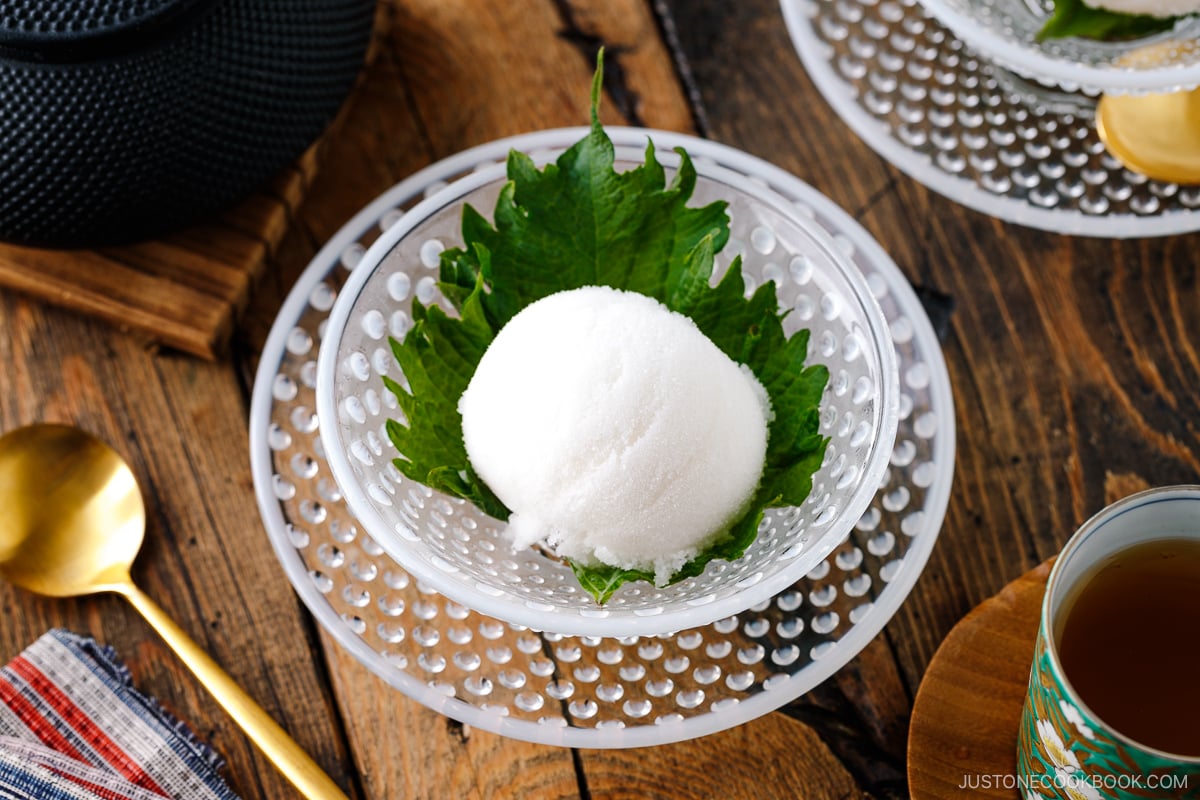 A white glass bowl containing Shiso Sorbet garnished with shiso leaf.