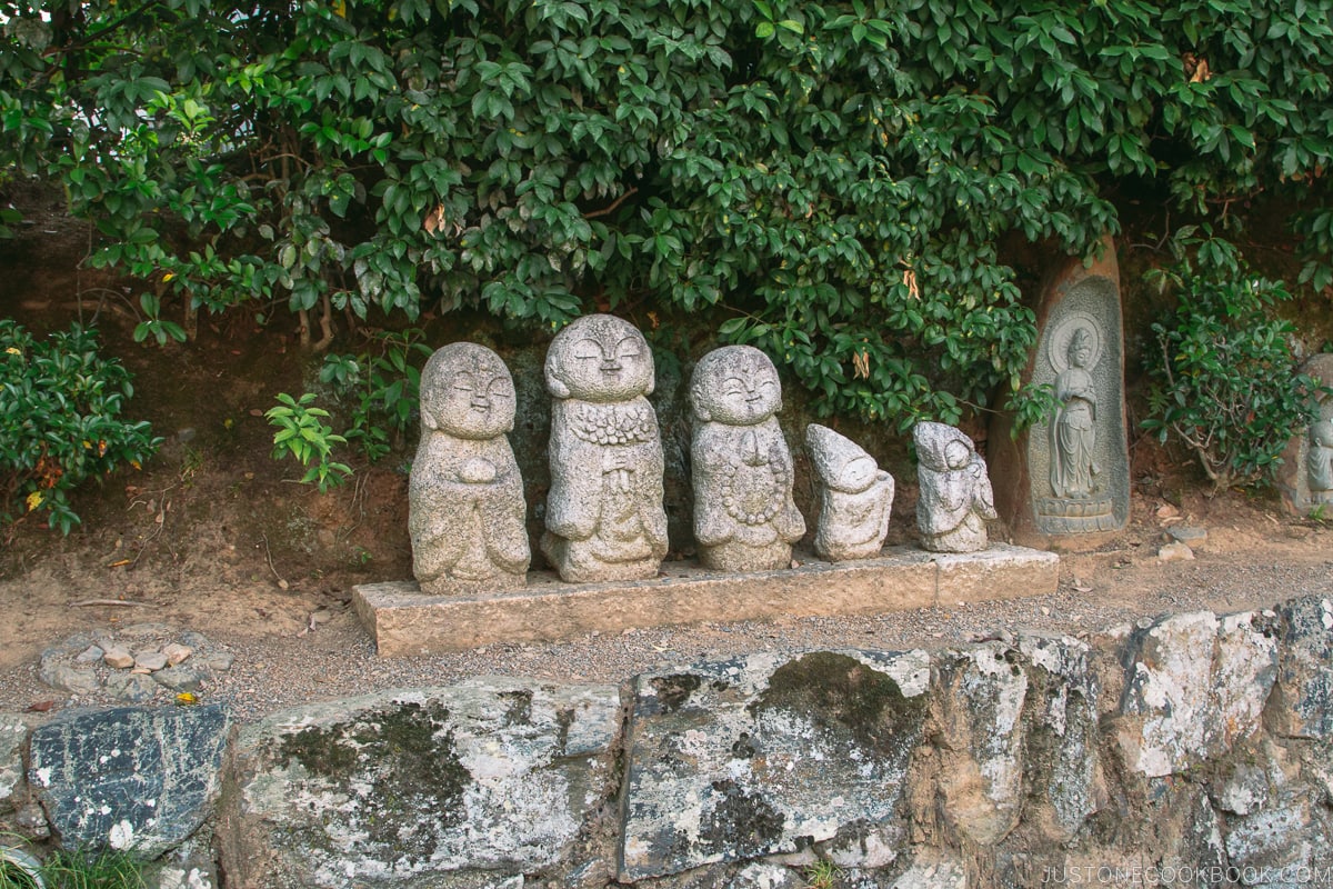 jizo statues on a rock wall