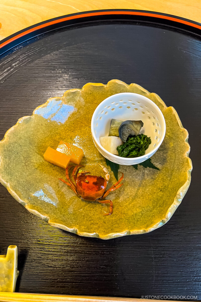 food in a small white dish on top of ceramic plate