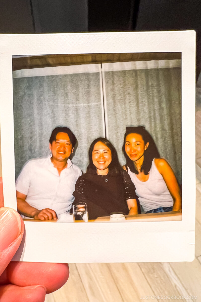 three adults in a Polaroid picture