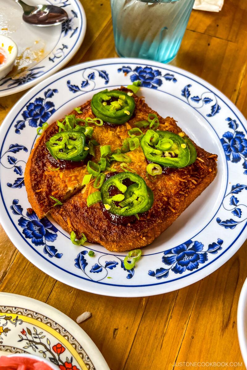 Coconut Shrimp Toast - Fried shrimp mousse on bread, toasted coconut flakes, sweet chili jam, jalapeño & scallion. Contains gluten & shrimp.