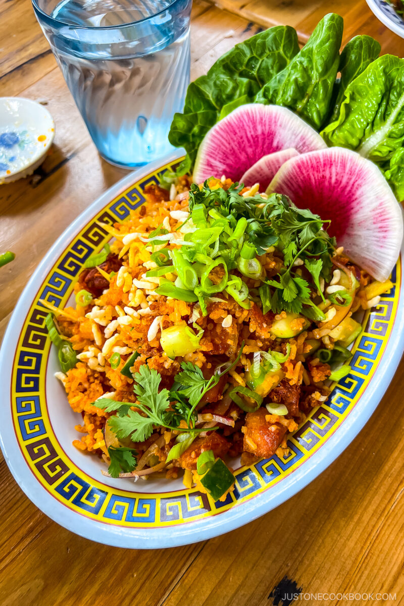 Crispy Rice Salad - Crispy red curry rice, cucumber, ginger, red onion, fish sauce, lime, Thai chili, herbs, scallion, puffed rice. Gluten free. Contains egg & fish sauce.