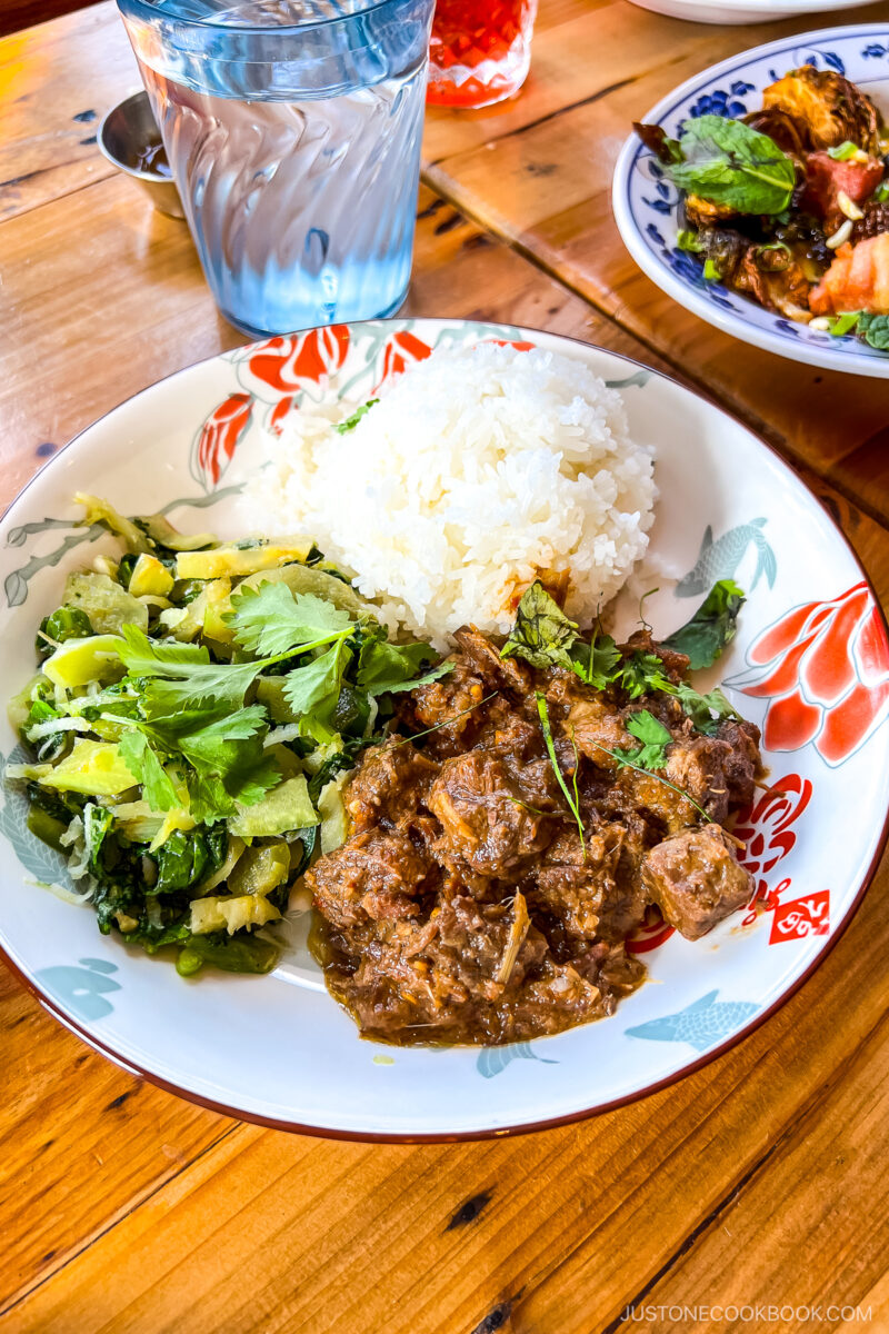 Beef Rendang - Beef slow cooked in a dry curry with rich spices, coconut cream & lemongrass, served with coconut rice & Chinese broccoli urap.