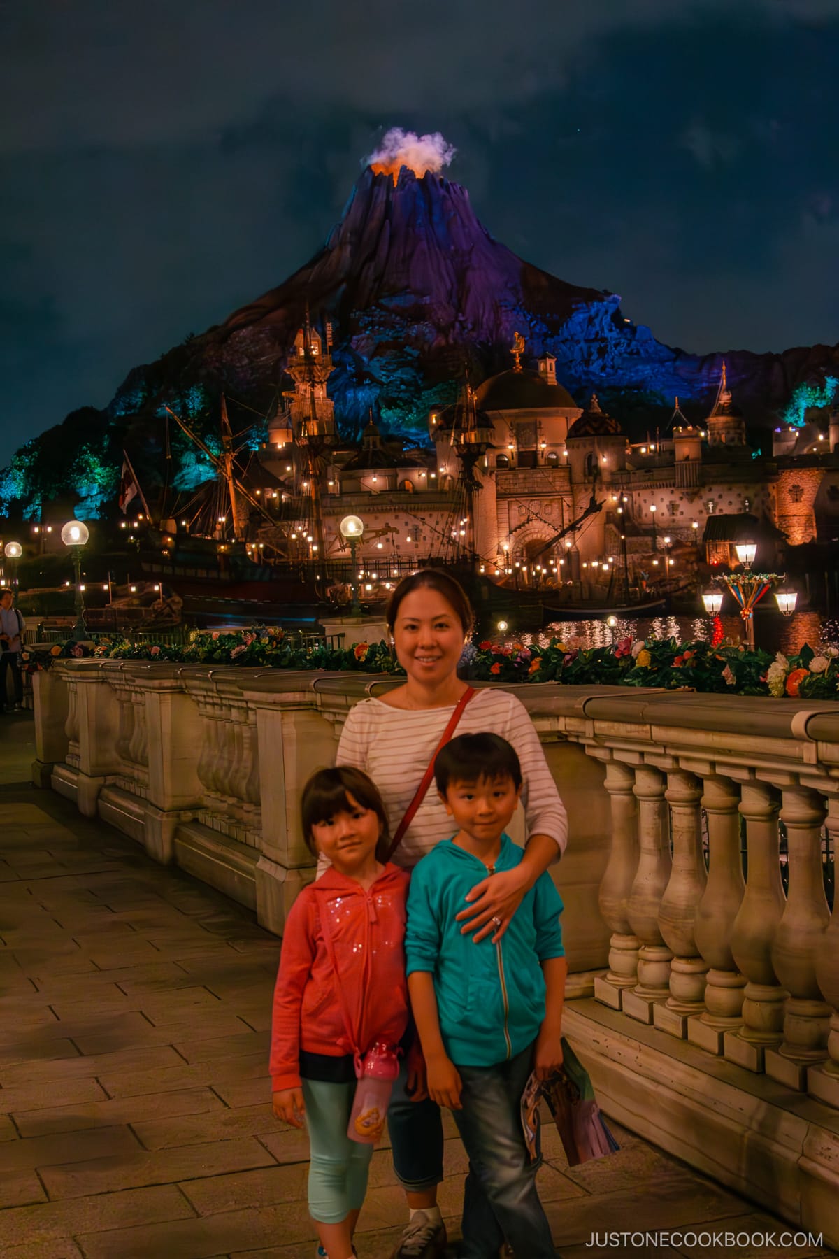 a women and two children in front of Mysterious Island Volcano