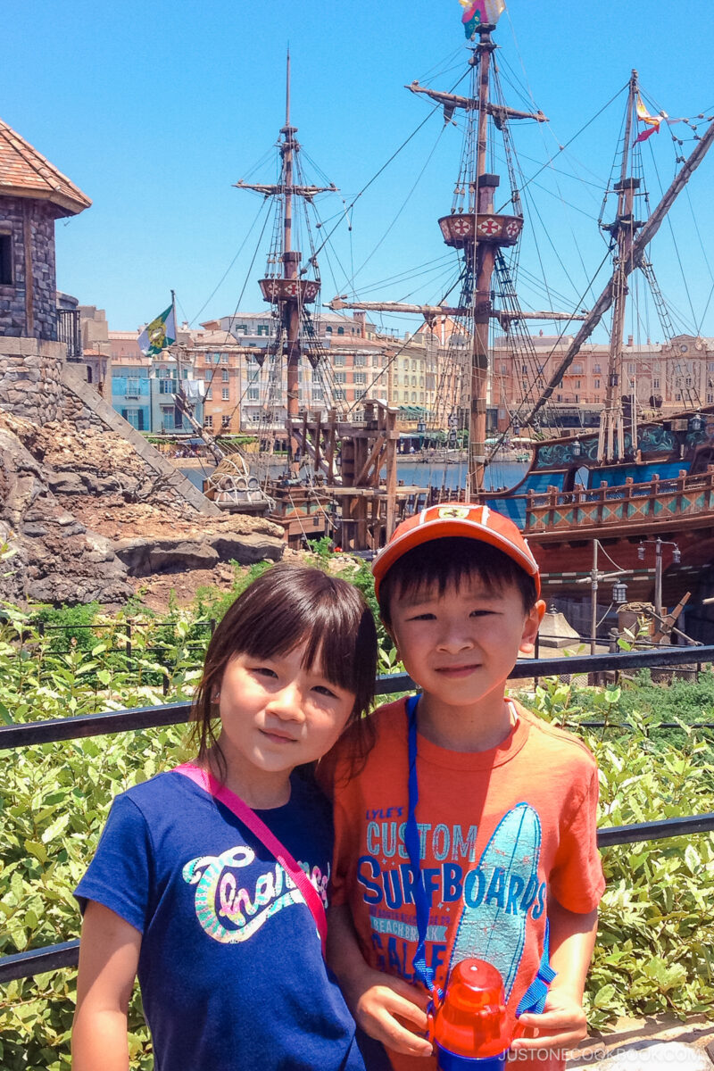 two children in front of a pirate ship