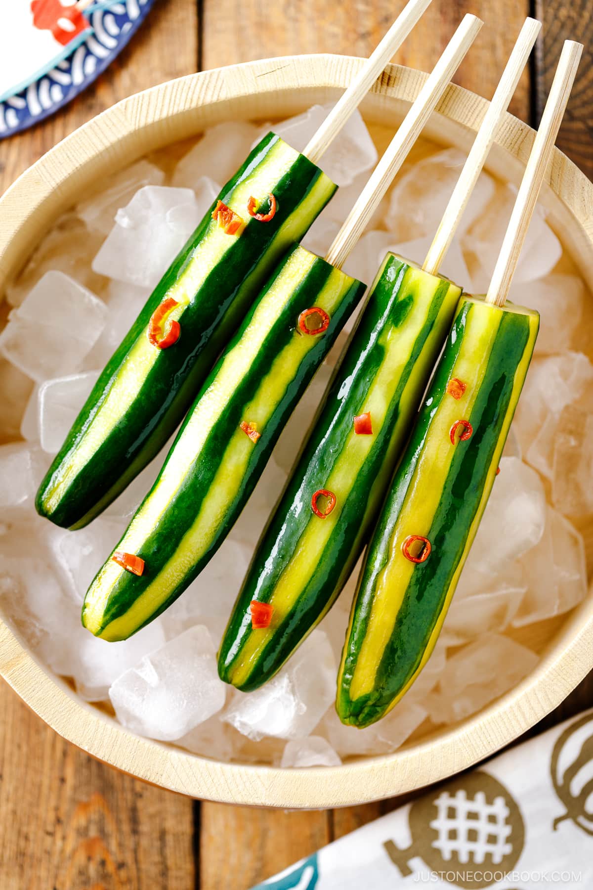 Japanese Cucumbers on a Stick served over iced cubes in wooden bowl.