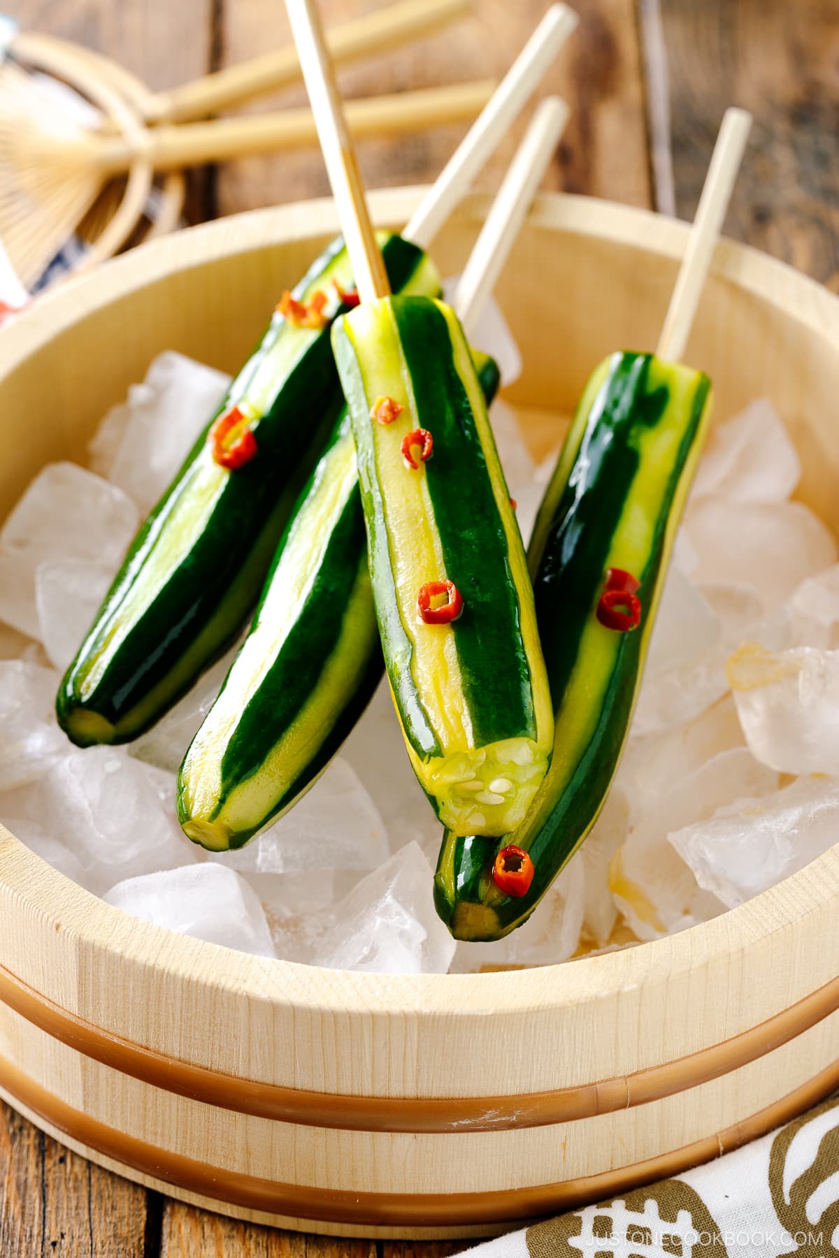 Japanese Cucumbers on a Stick served over iced cubes in wooden bowl.