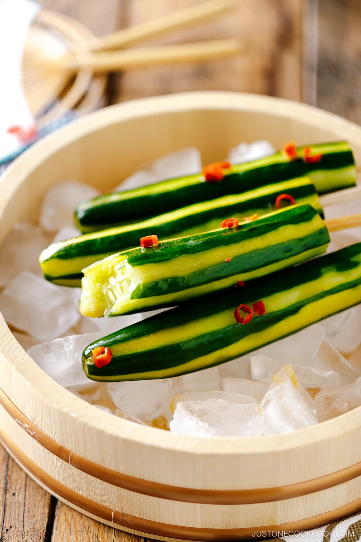 Japanese Cucumbers on a Stick served over iced cubes in wooden bowl.