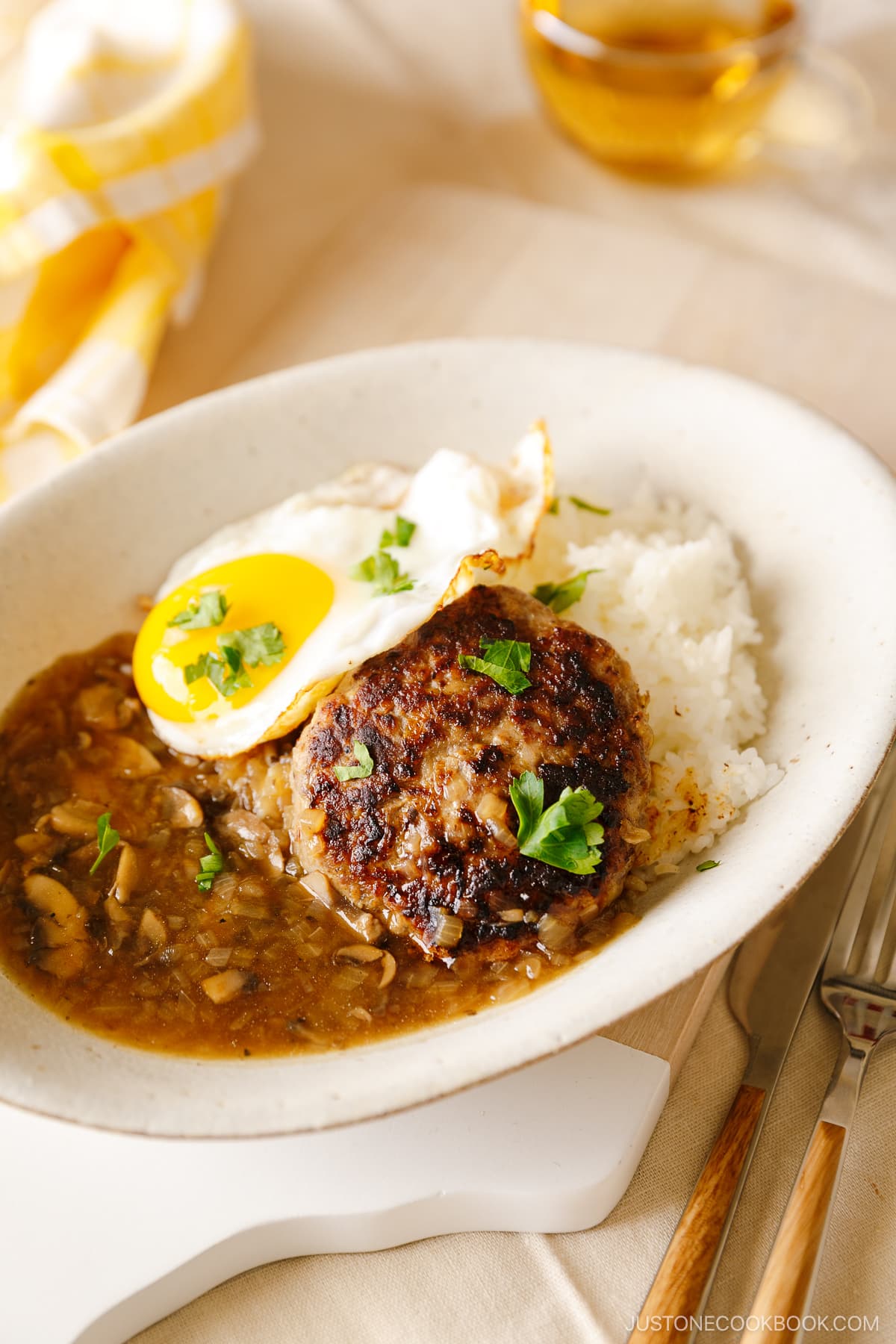 An oval dish containing Hawaiian dish called Loco Moco, consisting of hamburger steak, beef gravy, and fried egg over the steamed rice.
