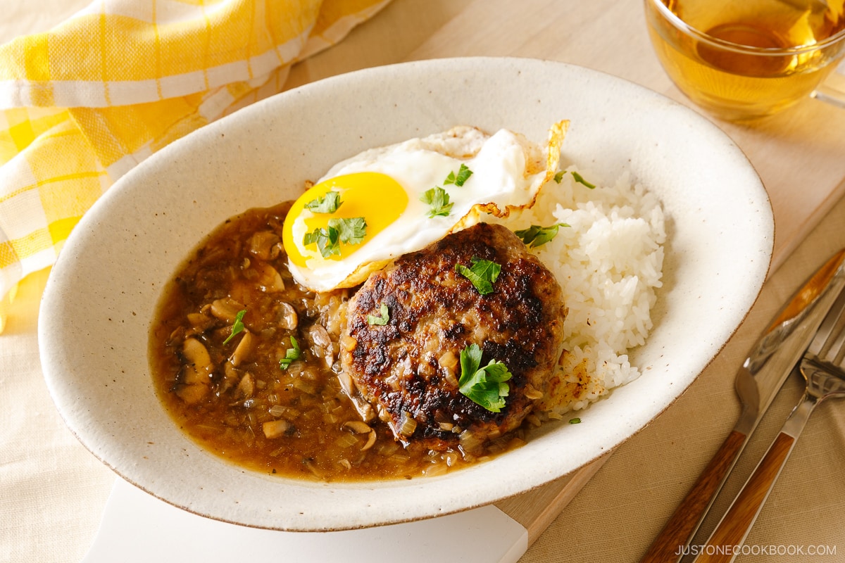 An oval dish containing Hawaiian dish called Loco Moco, consisting of hamburger steak, beef gravy, and fried egg over the steamed rice.