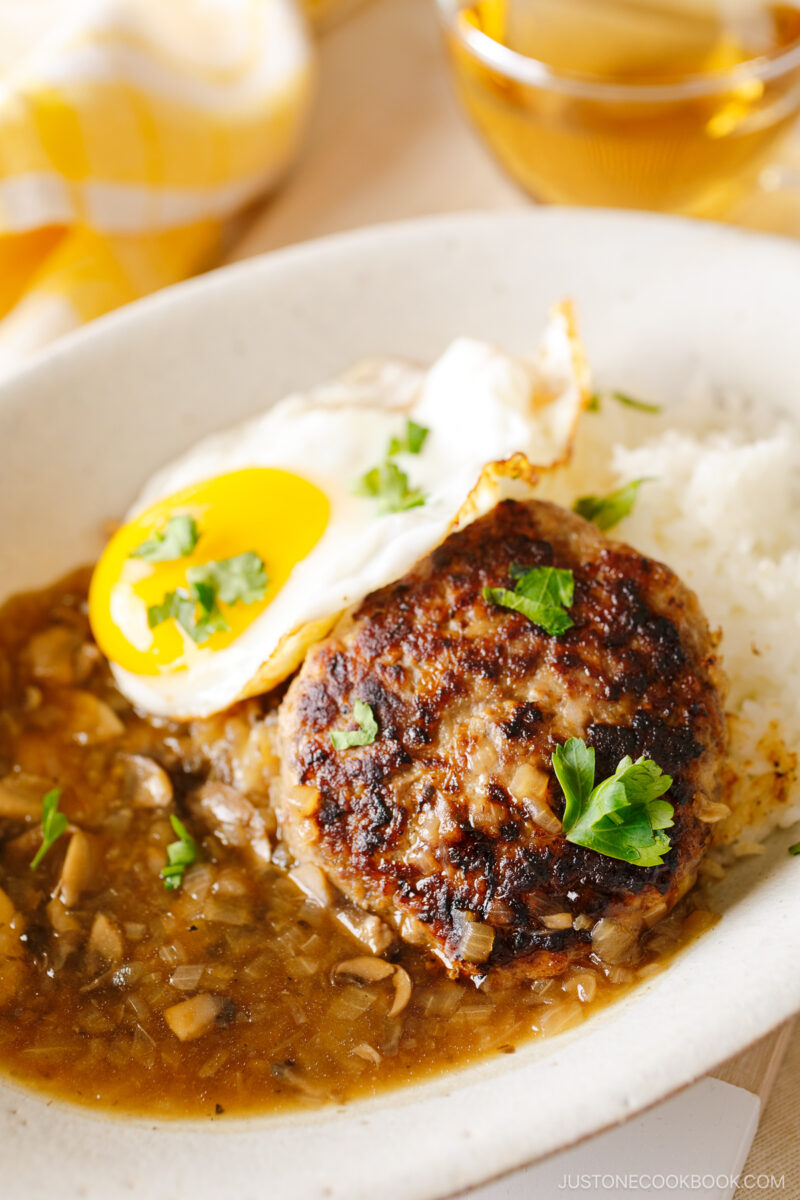 An oval dish containing Hawaiian dish called Loco Moco, consisting of hamburger steak, beef gravy, and fried egg over the steamed rice.