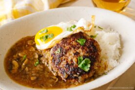 An oval dish containing Hawaiian dish called Loco Moco, consisting of hamburger steak, beef gravy, and fried egg over the steamed rice.