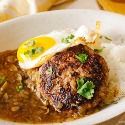 An oval dish containing Hawaiian dish called Loco Moco, consisting of hamburger steak, beef gravy, and fried egg over the steamed rice.